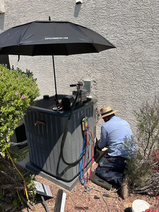 HVAC technician performing outdoor AC maintenance in East Lyme