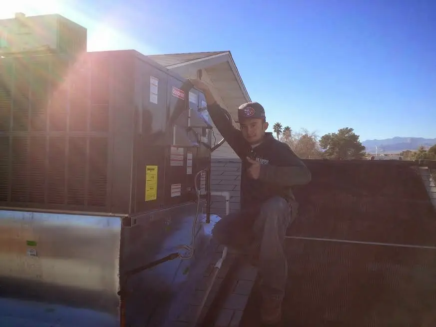 HVAC technician performing AC Tune-Up on a rooftop unit in East Lyme